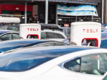 Lyngdal, Norway - August 02 2021: Electric cars charging at a Tesla supercharger ...