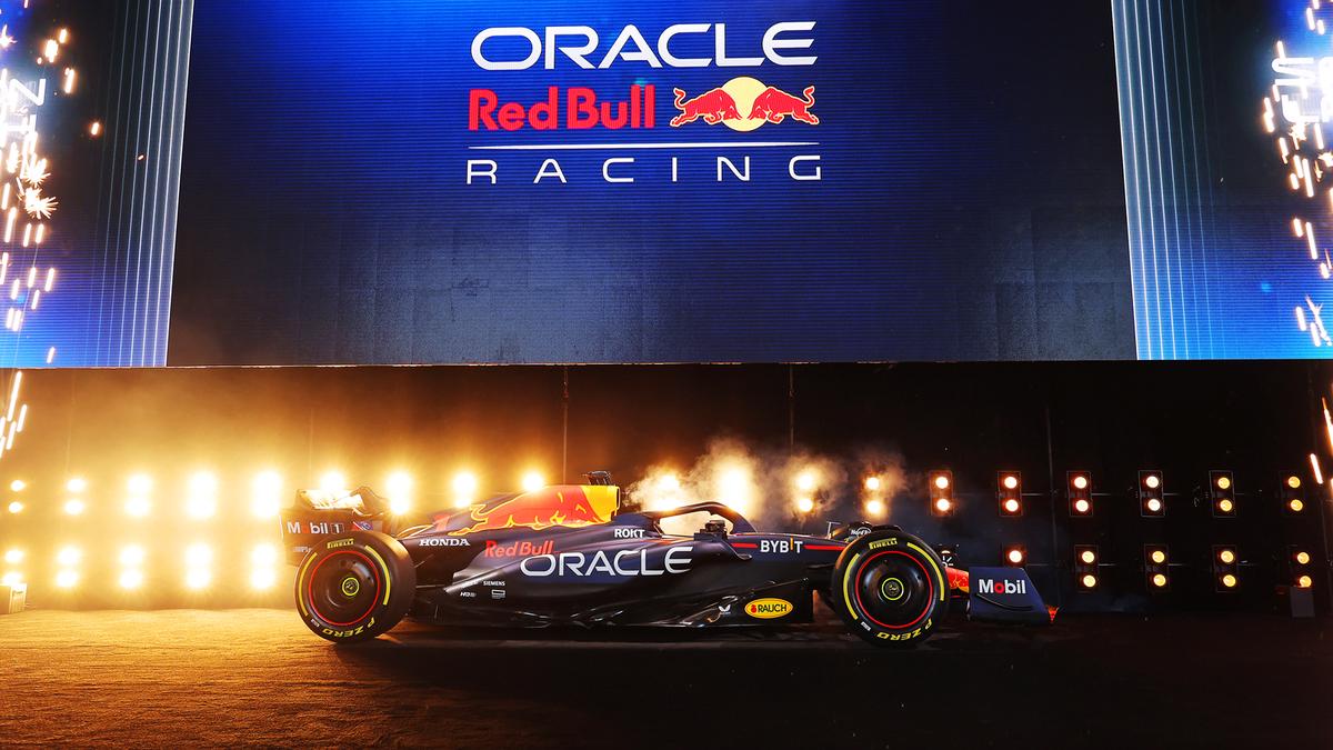 Een Formule 1-auto van Red Bull Racing wordt tentoongesteld op een podium met een groot bord