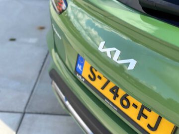 Close-up van de achterkant van een groene Kia XCeed, met het Kia-logo en een kentekenplaat van de Europese Unie (NL) met het nummer S-746-FJ.