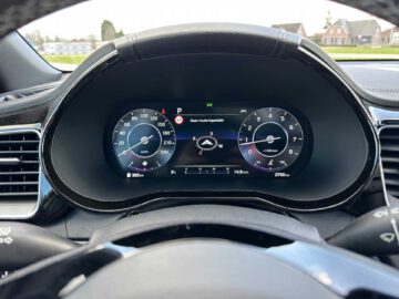 Close-up van een Kia XCeed-dashboard met verschillende meters en een digitaal display dat de snelheid, het brandstofniveau en de navigatieroute weergeeft. De snelheidsmeter geeft 95 km/u aan.