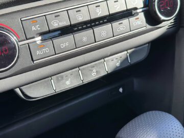 Close-up van het klimaatbedieningspaneel van een Kia XCeed, met knoppen voor airconditioning, ventilatorsnelheid, automatische klimaatregeling, ontdooiing en stoelverwarming. Temperatuurdisplay toont 20,0 graden Celsius.