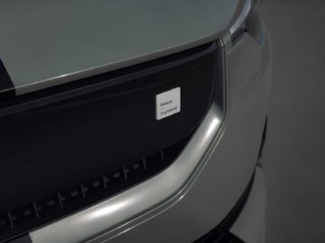 Close-up van de grille van de Polestar 2 BST edition 230 met een 'Polestar Engineered'-badge, met een strak en modern ontwerp in zilveren en zwarte accenten.