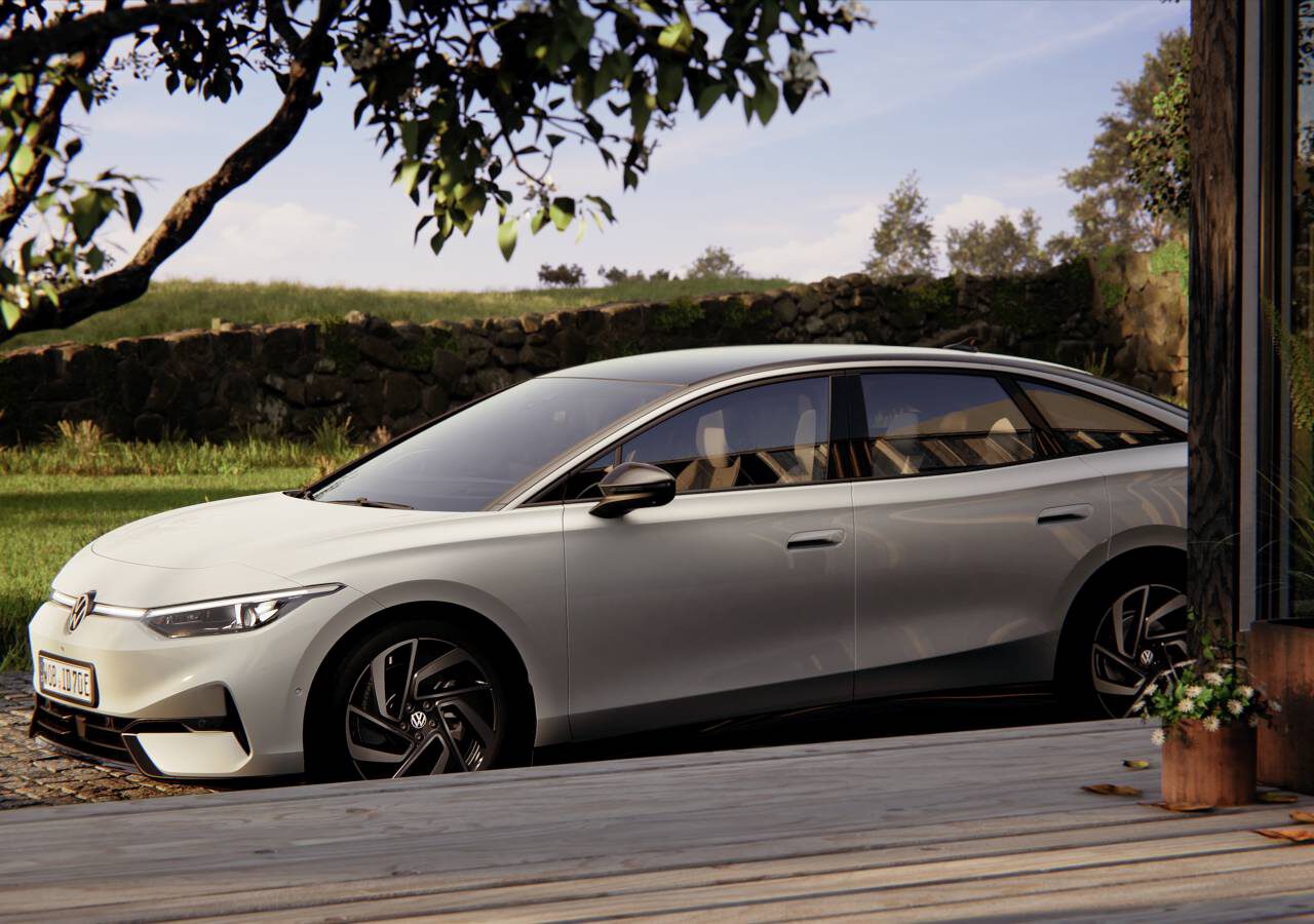 Een strakke witte elektrische sedan ID.7 staat geparkeerd in een serene buitenomgeving nabij een houten terras, omgeven door groen en struiken.
