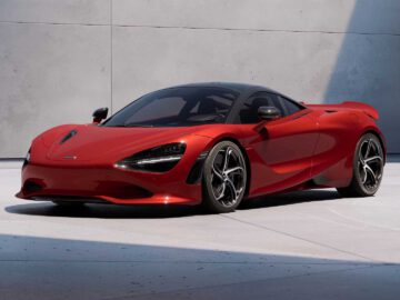 Op een gladde, lichtgrijze betonnen ondergrond staat een strakke, rode McLaren 750S met zwart dak en aerodynamisch design geparkeerd.