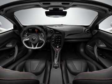 Interieur van de McLaren 750S, met het strakke, moderne dashboard van een hoogwaardige sportwagen, het digitale display en lederen stoelen met rode stiksels.