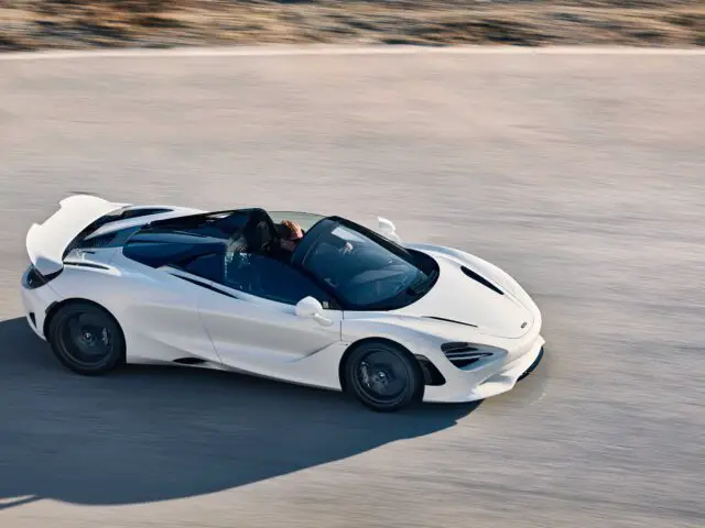 Een witte McLaren 750S converteerbare sportwagen rijdt op een gladde weg.