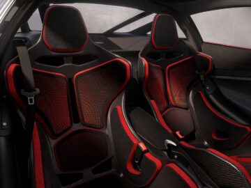 Interieur van een McLaren 750S-sportwagen met twee zwarte en rode kuipstoelen, strakke designelementen en een minimalistisch dashboard.