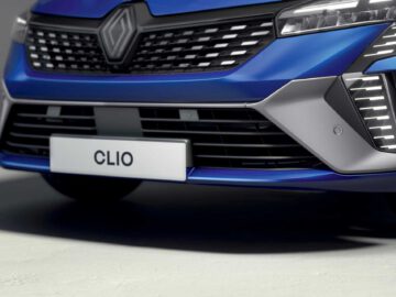 Close-up van de grille en bumper van een opvallende blauwe Renault Clio met een zichtbare kentekenplaat met de tekst 'CLIO.