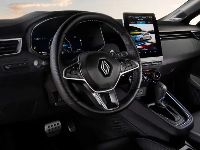 Interieur van een Renault Clio met het dashboard, het stuur, het digitale instrumentenpaneel en het centrale touchscreen. De versnellingspook bevindt zich handig rechts van het stuur.