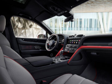 Interieur van een Bentley Bentayga EWB Mulliner met lederen stoelen, een strak dashboard met digitale displays, een multifunctioneel stuur en moderne designelementen.