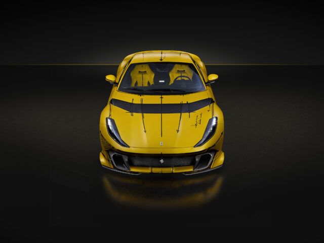 Een vooraanzicht van een slanke, gele Ferrari 812 Competizione, vastgelegd in een slecht verlichte omgeving, waarbij het aerodynamische ontwerp en de scherpe kenmerken worden benadrukt.