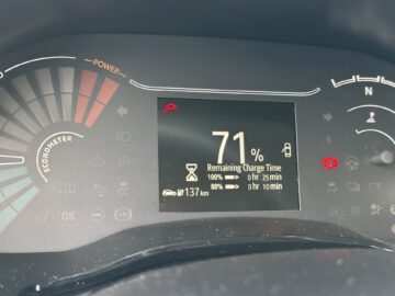 Close-up van een Dacia Spring Electric-dashboard met een batterijlading van 71%, een resterende actieradius van 137 km en een geschatte resterende oplaadtijd van 0 uur en 10 minuten tot 80% of 0 uur en 25 minuten tot 100%.