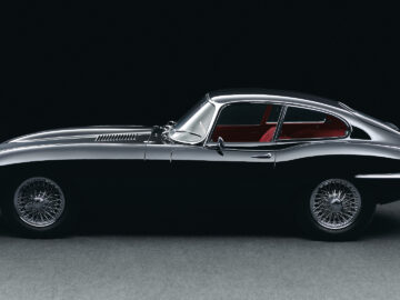 Une voiture de sport Jaguar F-Type SVR noire est présentée dans une pièce sombre.
