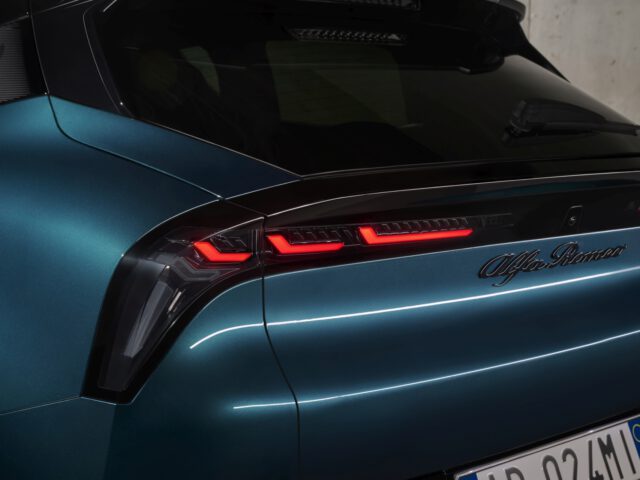 Rear view of a blue Alfa Romeo Milano vehicle, highlighting the model's taillights and nameplate.