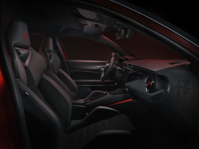 Interior deportivo Alfa Romeo MILANO con iluminación ambiental roja y asientos de competición.
