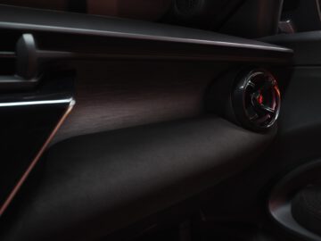 Luxuriöses Alfa Romeo MILANO Interieur Detail mit Holzarmaturenbrett und modernem Lüftungsgitter.