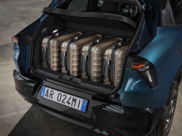 Luxury Alfa Romeo Milano SUV with open trunk, containing a set of golf clubs.