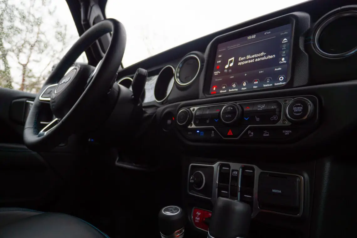 Dashboard and steering wheel of a Jeep Wrangler 4xe with infotainment system displaying a Bluetooth connection error.
