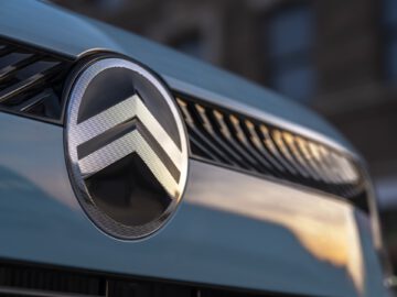 Nahaufnahme eines Citroën C3-Emblems mit einem doppelten Chevron-Logo auf einem blauen Kühlergrill.