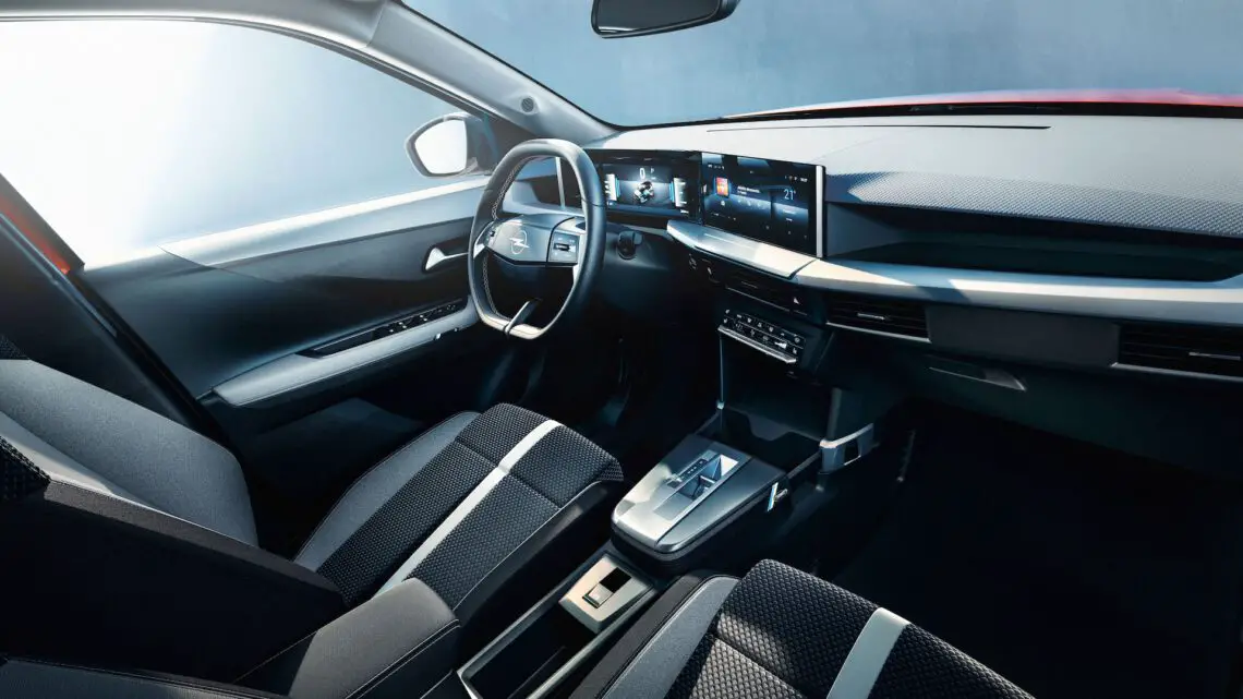 Auto-SUV-interieur met stuurwiel met embleem, digitaal dashboard en touchscreen op de middenconsole.