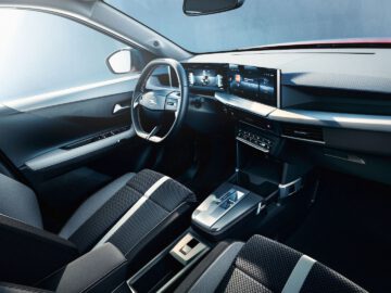 Auto-SUV-interieur met stuurwiel met embleem, digitaal dashboard en touchscreen op de middenconsole.