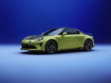 Een prachtige geelgroene Alpine A110-sportwagen met zwarte accenten wordt tentoongesteld op een gradiëntblauwe achtergrond, wat het strakke ontwerp en het personalisatieprogramma benadrukt.