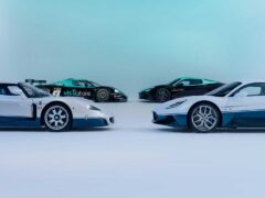 Vier sportwagens, waaronder de prachtige Maserati MC20 en MC12, worden tentoongesteld in een studio. Ze zijn gerangschikt in een halve cirkel met twee witte en blauwe auto's op de voorgrond en twee donkerder gekleurde auto's op de achtergrond.