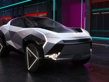 Een futuristisch, veelhoekig elektrisch voertuig met verlichte randen staat 's nachts geparkeerd in een natte straat te midden van neonverlichte gebouwen, wat doet denken aan de technologie die in Sunderland is ontwikkeld voor de Nissan Qashqai.