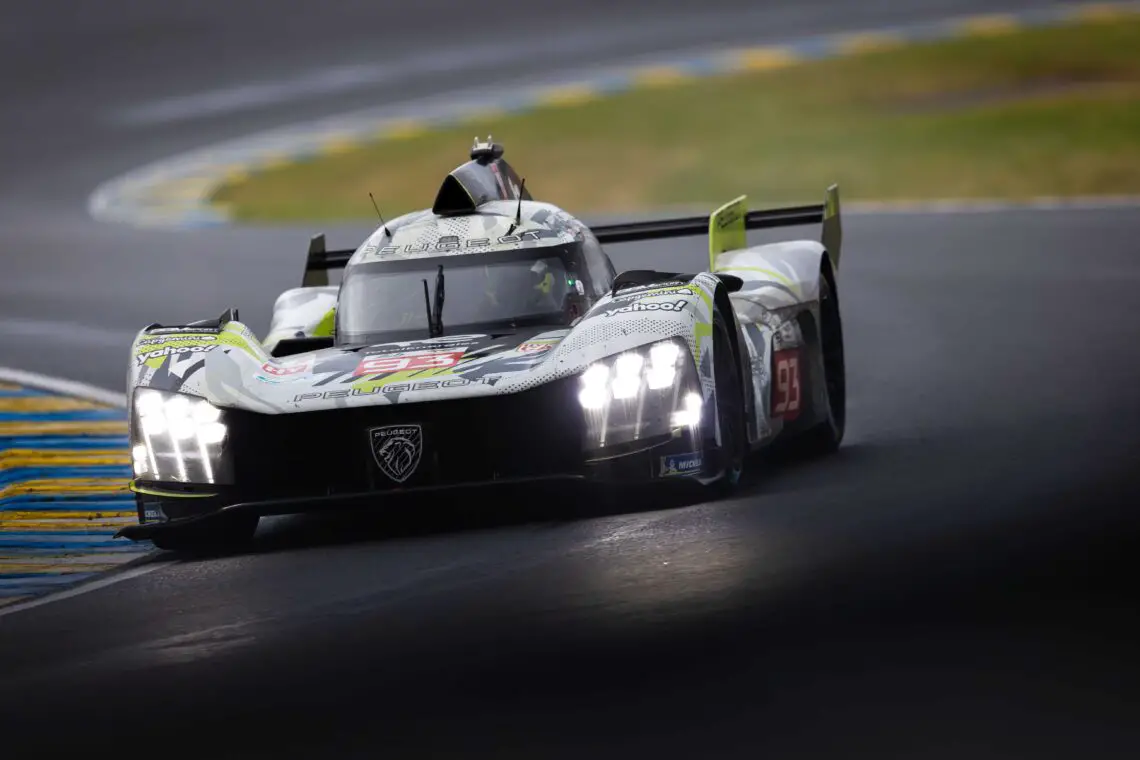 Een Peugeot 9X8 raceauto met nummer 93 op het circuit, voorzien van felle koplampen en diverse sponsorlogo's. De auto leunt een bocht in op een verharde racebaan.