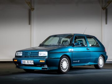 A classic blue-green-blue Volkswagen hatchback, often affectionately called a 