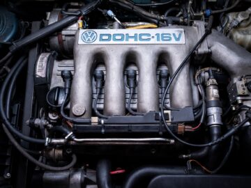 Close-up of a Volkswagen DOHC-16V engine, with the valve cover, wiring and other components in detailed, well-maintained condition. This motorsports report captures the heart of one of the classic Golfs that enthusiasts love.