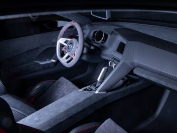 Modern auto-interieur met een minimalistisch ontwerp met een strak dashboard, een driespaaks stuurwiel en kuipstoelen. De oppervlakken zijn gemaakt van een combinatie van leer en koolstofvezelmaterialen, net zoals je die in een Volkswagen Golf aantreft.