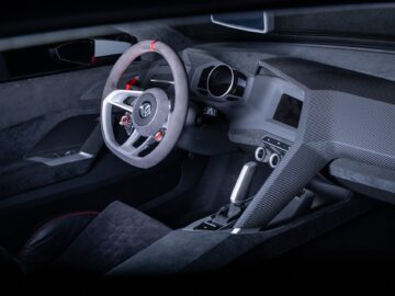 Inside view of a modern Volkswagen Golf with a sleek design, including carbon fiber accents, a sport steering wheel and a digital dashboard.