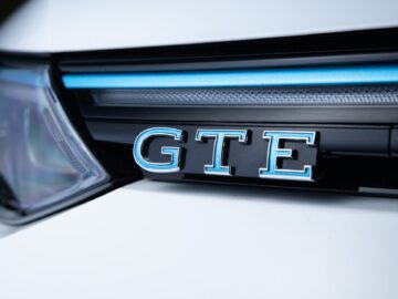 Close-up van de grille van een Volkswagen Golf, met een 'GTE'-badge met stijlvolle blauwe accenten.