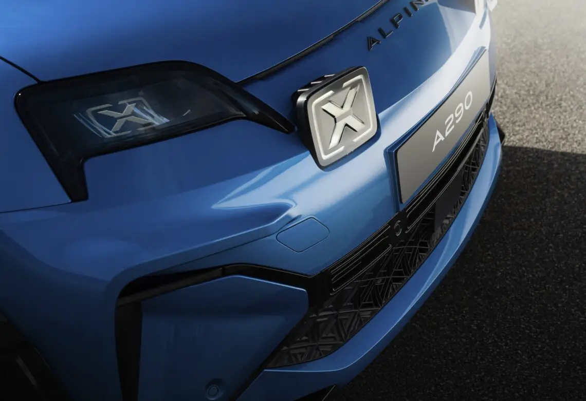 Close-up van de voorkant van een blauwe Alpine A290, met de nadruk op het logo op de grille en gedetailleerde koplampen, legt de essentie vast van deze elektrische hot hatchback die geworteld is in de geest van de Renault 5.