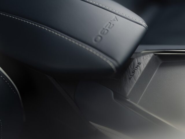 Close-up van een auto-interieur met donkerlederen bekleding met zichtbare stiksels en de tekst in reliëf met de tekst "A290" en "ALPINE", wat de elegantie van het ontwerp van de elektrische hot hatchback Alpine A290 benadrukt.