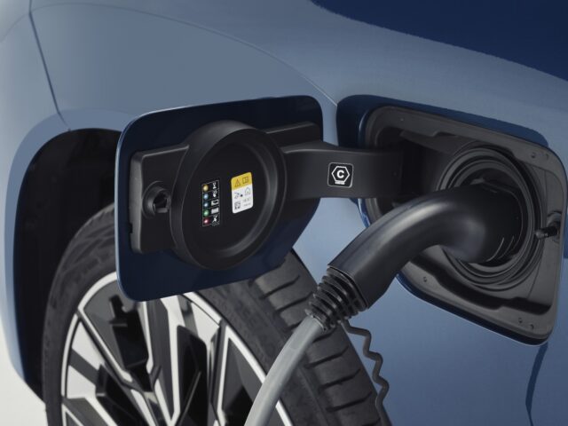 Nahaufnahme eines Elektrofahrzeugs beim Aufladen. Das Ladekabel ist in die Steckdose an der Seite des neuen BMW X3 von 2024 eingesteckt und verdeutlicht den nahtlosen Übergang von Benzin- und Dieselantrieb zu modernster Elektrotechnologie.