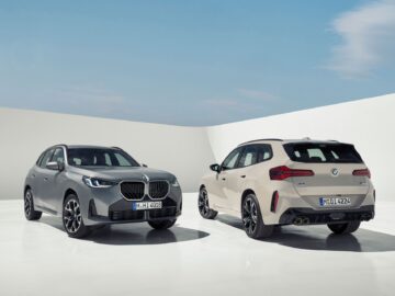 Zwei New BMW X3 SUVs sind in einem minimalistischen, offenen Raum mit strahlend blauem Himmel geparkt. Einer blickt nach vorne, der andere zeigt das Heck. Beide 2024-Modelle haben sichtbare Nummernschilder und ein schlankes Design, das ihre Benzin- und Dieseltauglichkeit unterstreicht.