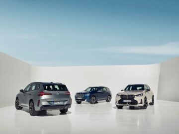 Trois SUV BMW 2024, dont le BMW X3, sont présentés dans un cadre lumineux et minimaliste. Les véhicules sont l'un en gris, l'autre en bleu et le troisième en blanc, positionnés de manière à mettre en évidence différents angles. Un ciel bleu vif forme l'arrière-plan. Ces modèles sont équipés de moteurs à essence et diesel.