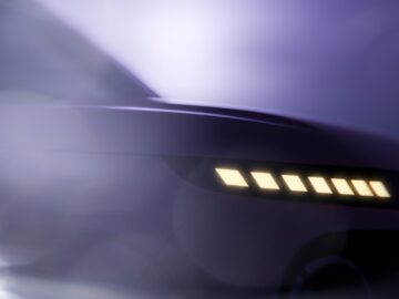Nahaufnahme der linken Vorderseite eines Hyundai INSTER, die das schlanke Design und die beleuchteten Scheinwerfer vor einem weichen, unscharfen Hintergrund hervorhebt.
