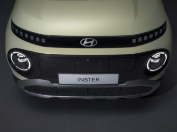 Vue avant d'une Hyundai INSTER avec des phares ronds, une calandre noire et une plaque d'immatriculation blanche avec le mot 
