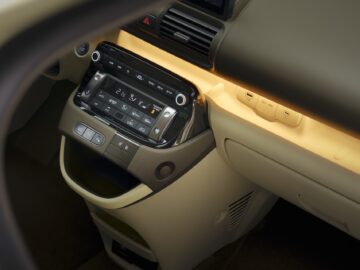Primer plano del salpicadero del Hyundai INSTER con una pantalla táctil con ajustes de climatización, botones e iluminación ambiental. El precio de este VE ofrece una interfaz moderna combinada con tecnología avanzada.