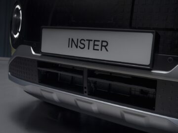 Close-up van de voorkant van een Hyundai EV-prijspakker, met een kentekenplaat met de tekst "INSTER" en een gedetailleerd bumperontwerp.