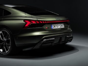 Achteraanzicht van een groene Audi RS e-tron GT met de achterlichten, bumper en kentekenplaat, wat de indrukwekkende prestaties met 1.000 pk onder de motorkap benadrukt.