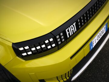 Primer plano de una parrilla amarilla brillante del Fiat Grande Panda con el logotipo de Fiat y una matrícula en la que se lee 