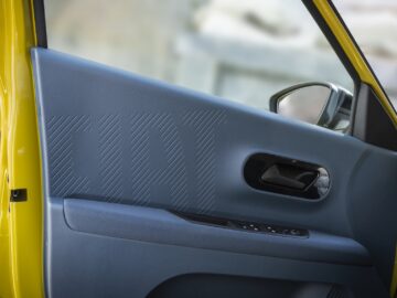 Gros plan sur le panneau intérieur de la porte d'une Fiat Grande Panda jaune, avec un design épuré et le mot 