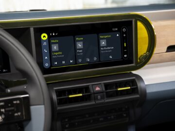 Primer plano del salpicadero de un Fiat Grande Panda con una pantalla digital con opciones multimedia, de teléfono y navegación. La hora es las 12.30 y en el interior hay varios botones de control y rejillas de ventilación debajo de la pantalla.