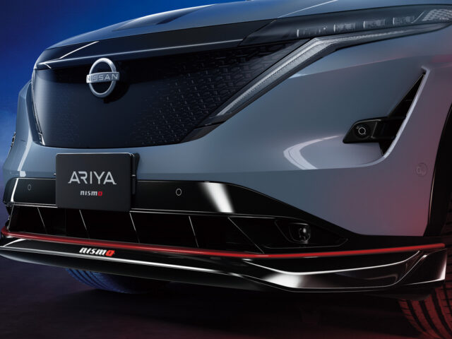 Vooraanzicht van de Nissan ARIYA Nismo, met de grille, het logo en sportieve designdetails met rode accenten.