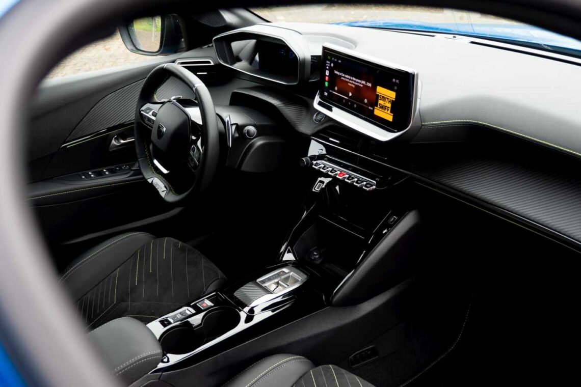 Innenraum des Peugeot 208 Hybrid 2024 mit digitalem Armaturenbrett, Touchscreen-Display und eleganten schwarz-grauen Sitzen - eine Option, die in den Niederlanden schnell an Beliebtheit gewinnt.