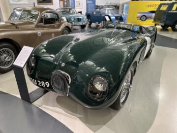 In het British Motor Museum wordt naast andere historische voertuigen een klassieke donkergroene sportwagen tentoongesteld, die bezoekers een kijkje in de autogeschiedenis biedt.